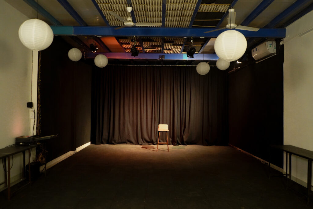 The empty Harkat black box studio with a single chair on stage