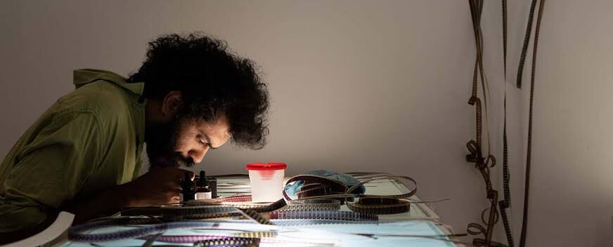 A karigar inspecting photochemical film by hand